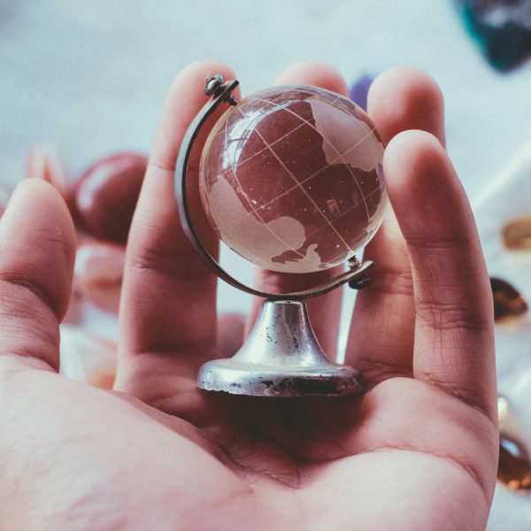 Globus aus Glas in einer Hand Globus aus Glas in einer Hand