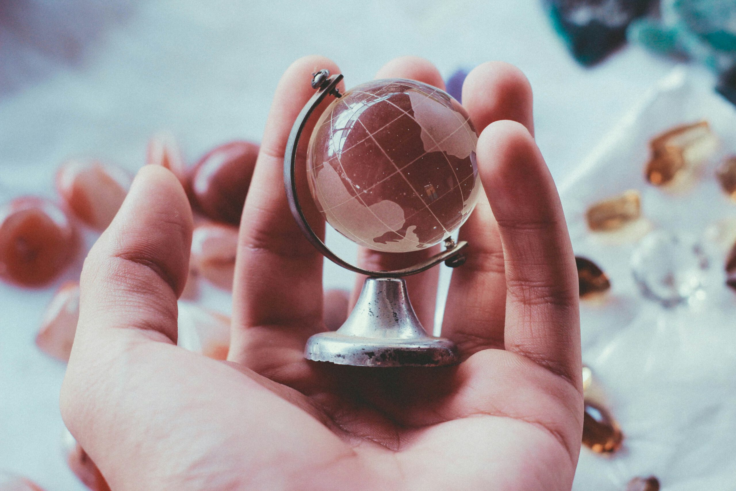 Globus aus Glas in einer Hand Globus aus Glas in einer Hand